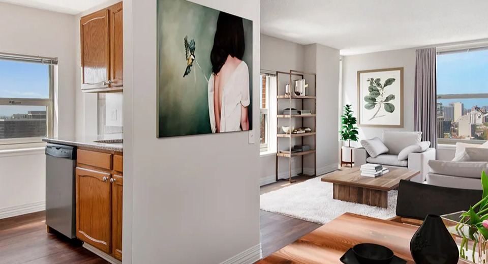 Open layout at 100 W Chestnut in Chicago connecting the kitchen with stainless appliances to a bright living room and dining area with city views