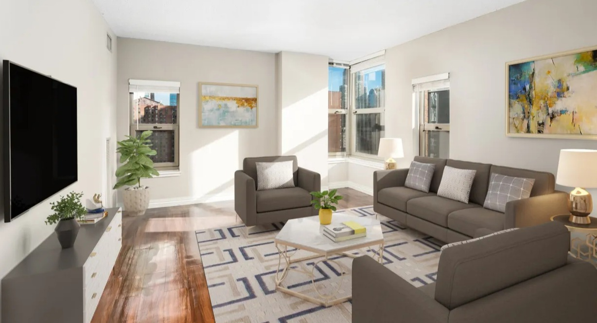 Spacious living room at 100 W Chestnut in Chicago featuring corner windows, modern sofa set, wall-mounted TV, and abundant natural light