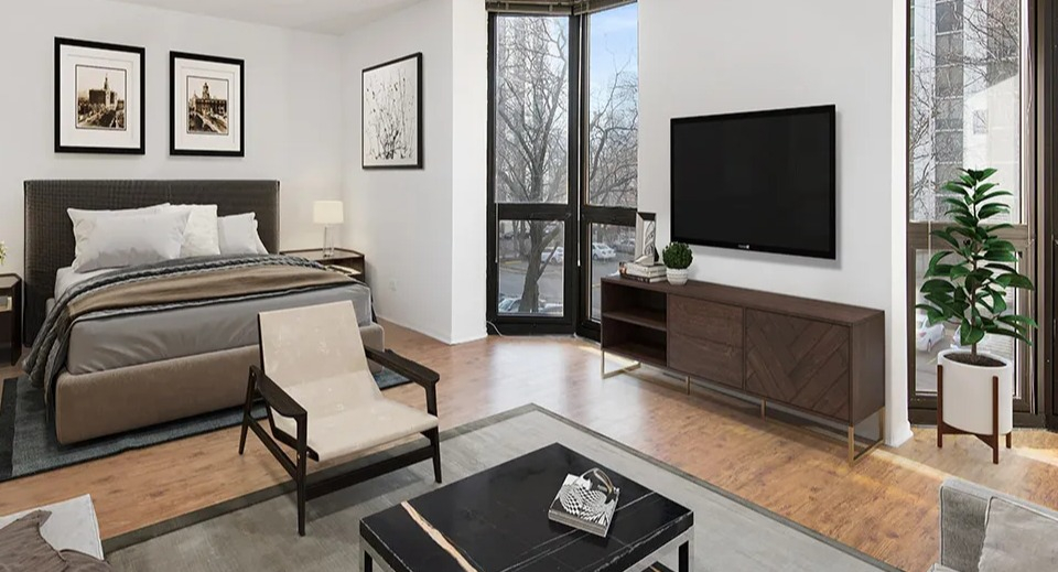 Bright studio at 1000 N LaSalle in Chicago with queen bed, TV, sectional sofa, wood floors, and floor-to-ceiling windows with street views