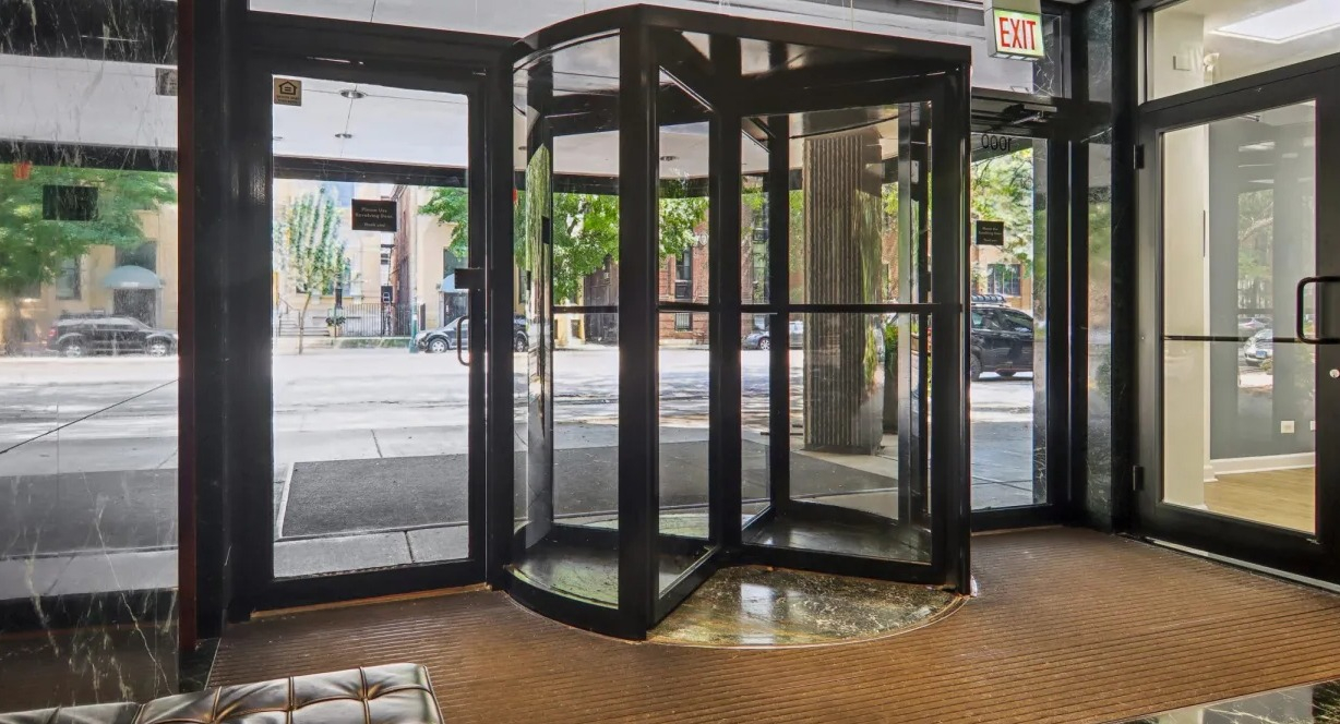 Lobby entrance at 1000 N LaSalle in Chicago featuring revolving glass door, polished black marble walls, and seating area