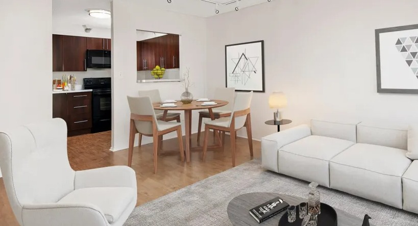 Modern living room at 1000 N LaSalle in Chicago with white sofa, dining area, wood floors, and open kitchen with dark cabinetry