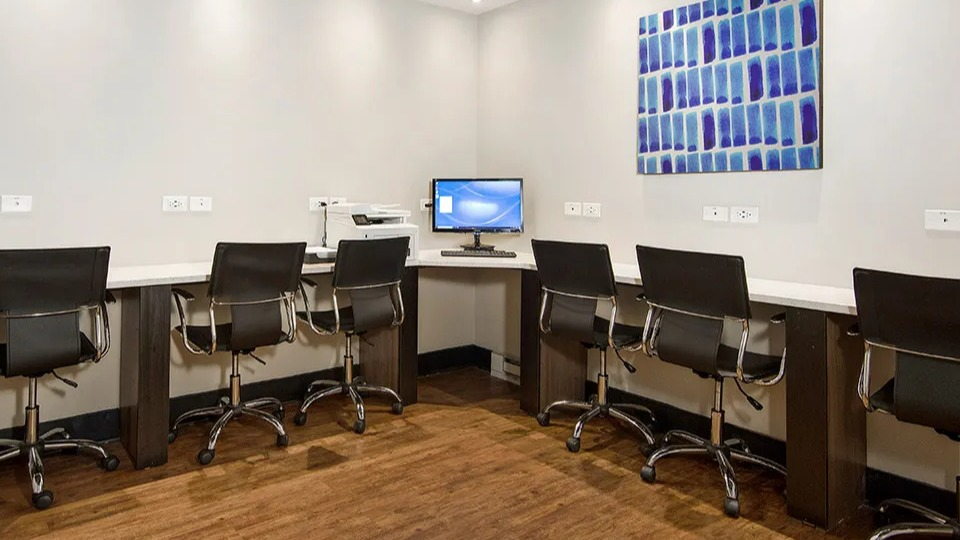 Resident business center featuring long counters, task chairs on casters, ample outlets, and a desktop station for printing at 1000 N LaSalle in Chicago