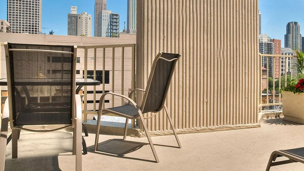 Rooftop sundeck at 1000 N LaSalle in Chicago with lounge chairs, outdoor seating, and skyline views of the Gold Coast neighborhood