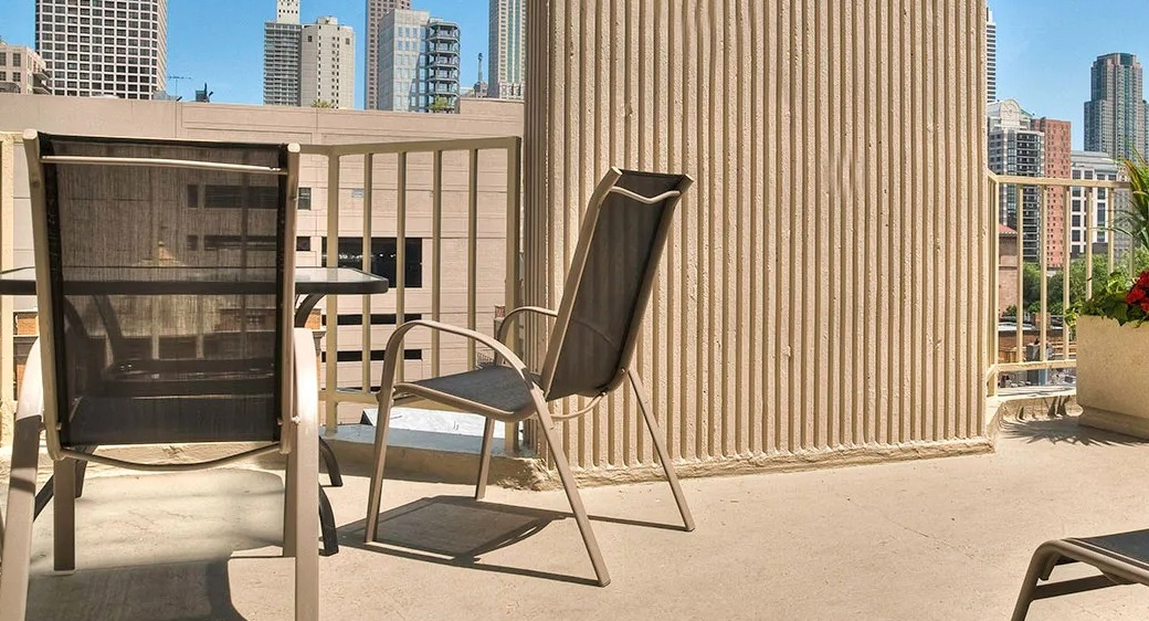 Rooftop sundeck at 1000 N LaSalle in Chicago with lounge chairs, outdoor seating, and skyline views of the Gold Coast neighborhood