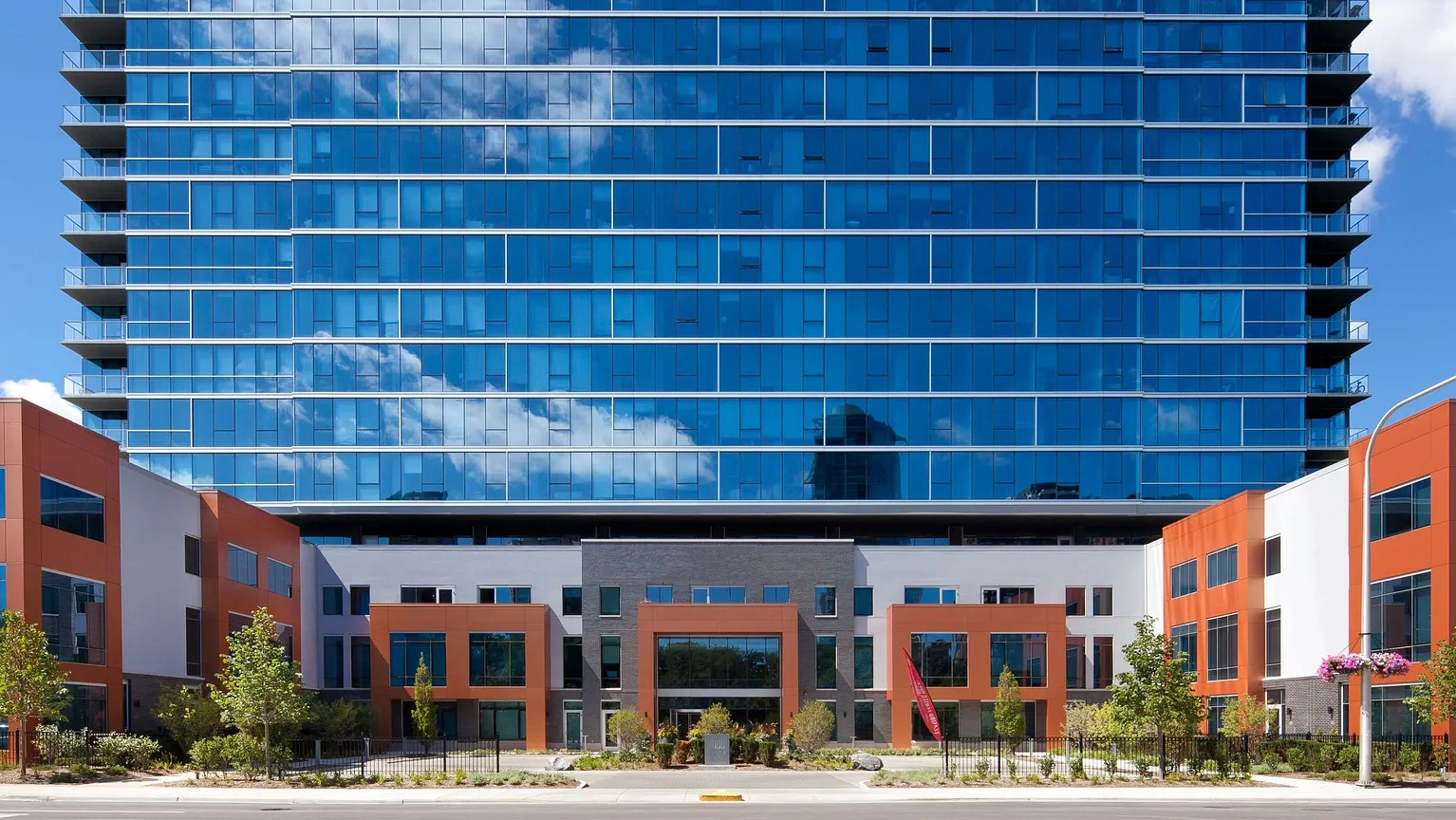 Exterior view of 1000 South Clark apartments showing modern glass high-rise architecture with orange accents in downtown Chicago