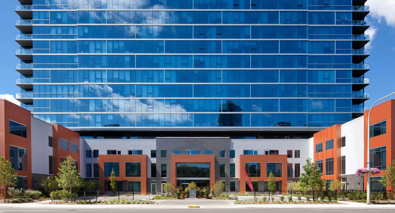 Exterior view of 1000 South Clark apartments showing modern glass high-rise architecture with orange accents in downtown Chicago