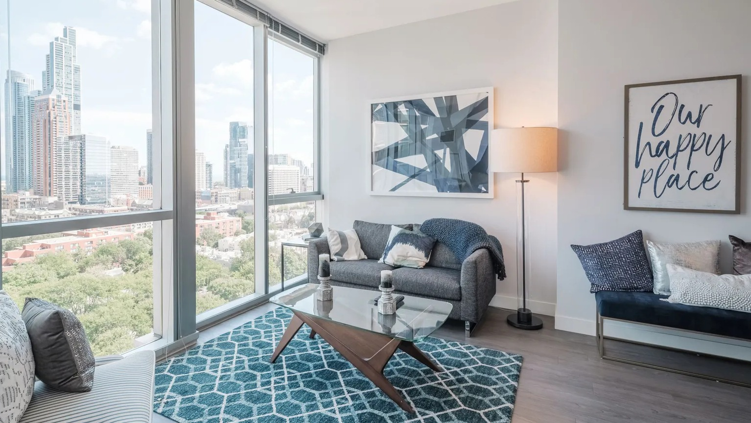 Cozy living room with modern furniture, artwork, and floor-to-ceiling windows overlooking Chicago skyline at 1000 South Clark apartments