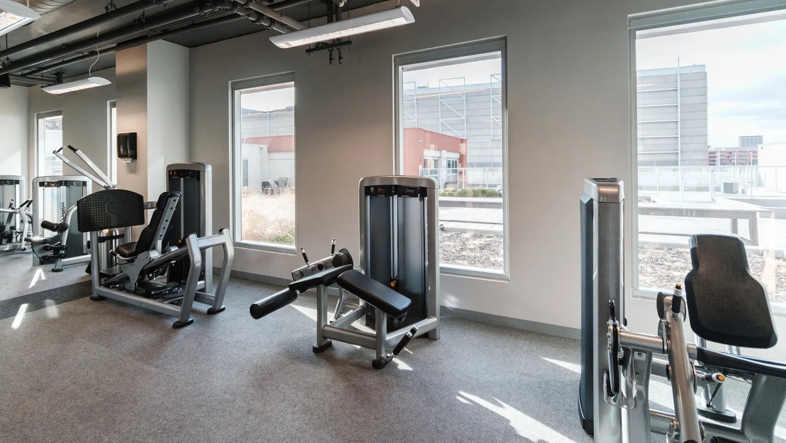 Spacious fitness center with modern strength-training equipment and natural light at 1000 South Clark apartments in Chicago