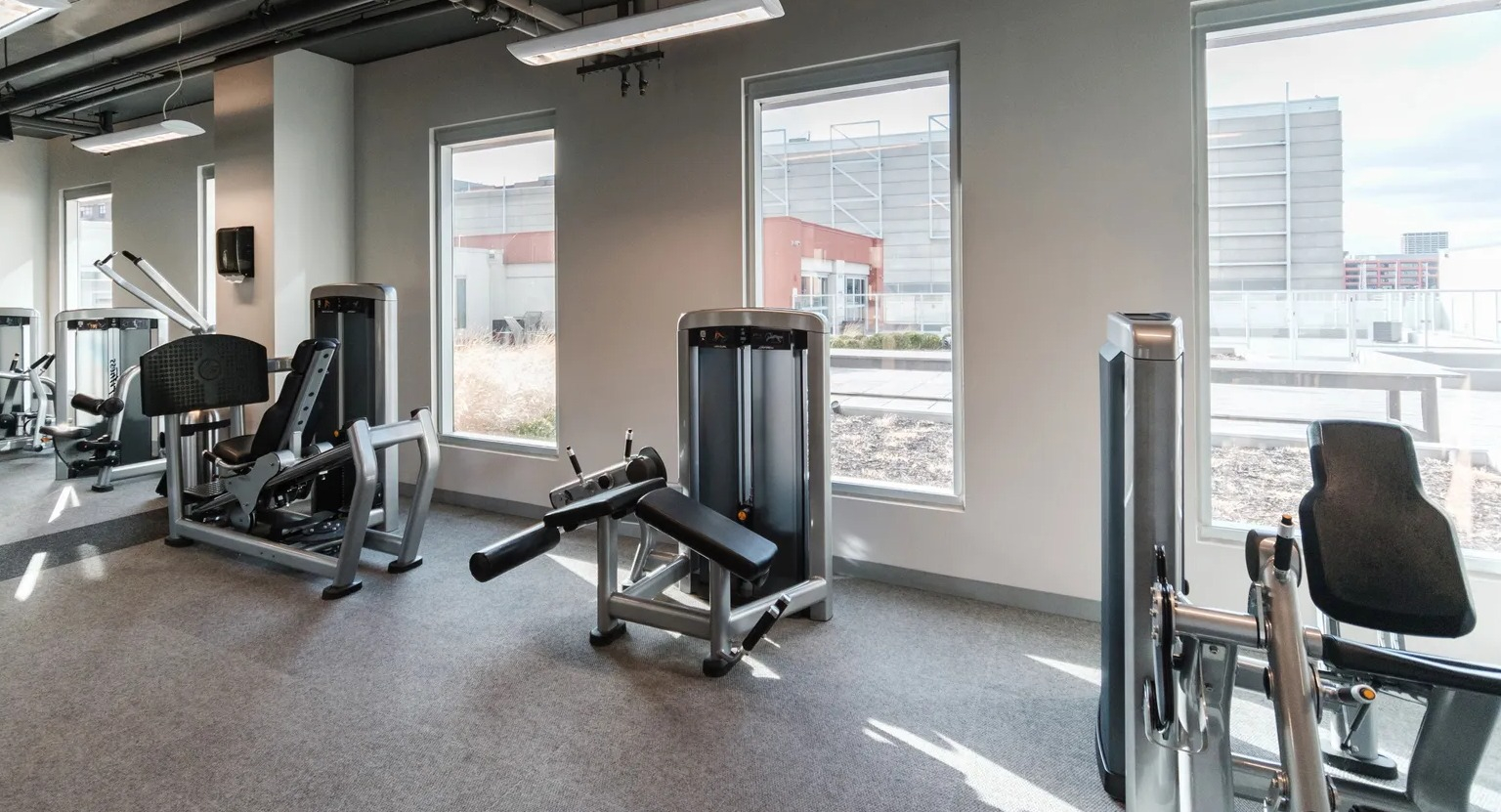 Spacious fitness center with modern strength-training equipment and natural light at 1000 South Clark apartments in Chicago