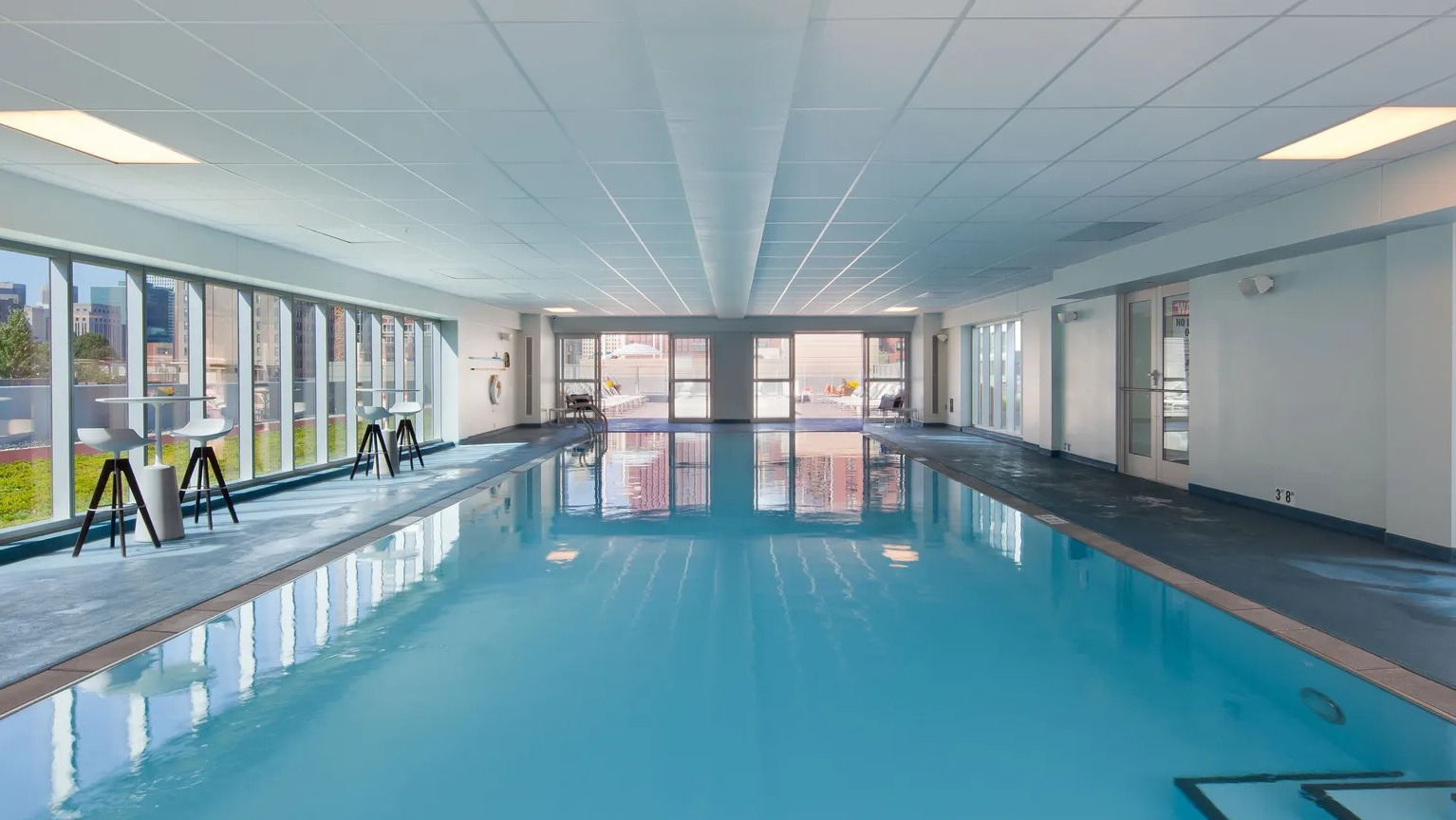 Large indoor swimming pool with natural light and city views at 1000 South Clark apartments in Chicago