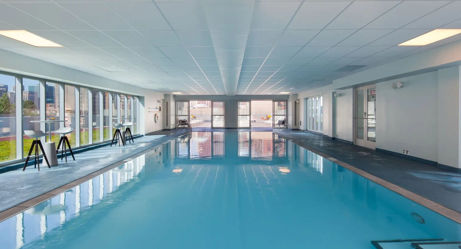 Large indoor swimming pool with natural light and city views at 1000 South Clark apartments in Chicago
