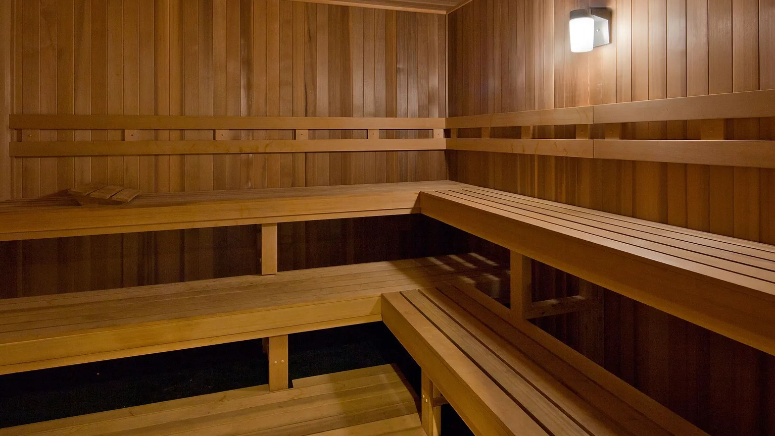 Luxury wooden sauna room with tiered seating for relaxation and wellness at 1000 South Clark apartments in Chicago