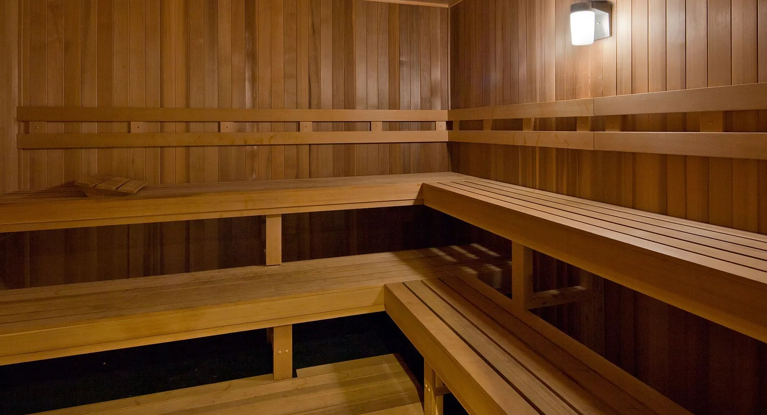 Luxury wooden sauna room with tiered seating for relaxation and wellness at 1000 South Clark apartments in Chicago