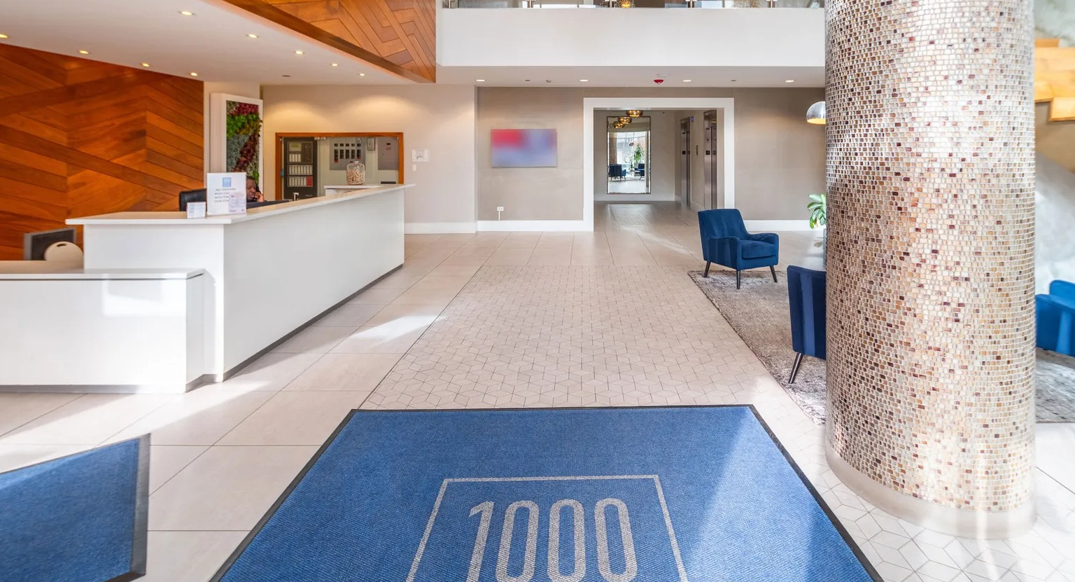Modern lobby with wood accent walls, chandelier, front desk, and stylish seating at 1000 South Clark apartments in Chicago