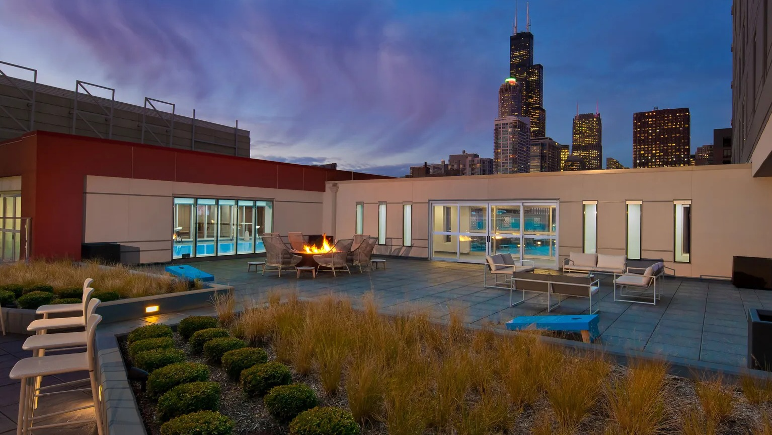 Rooftop lounge with firepit, seating, and skyline views at 1000 South Clark apartments in Chicago