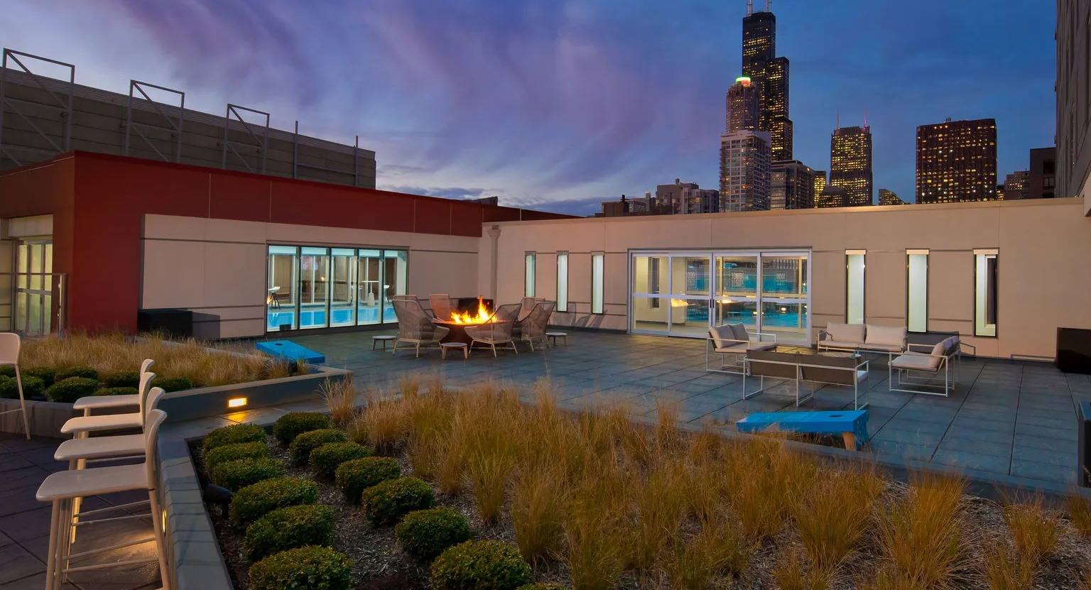 Rooftop lounge with firepit, seating, and skyline views at 1000 South Clark apartments in Chicago