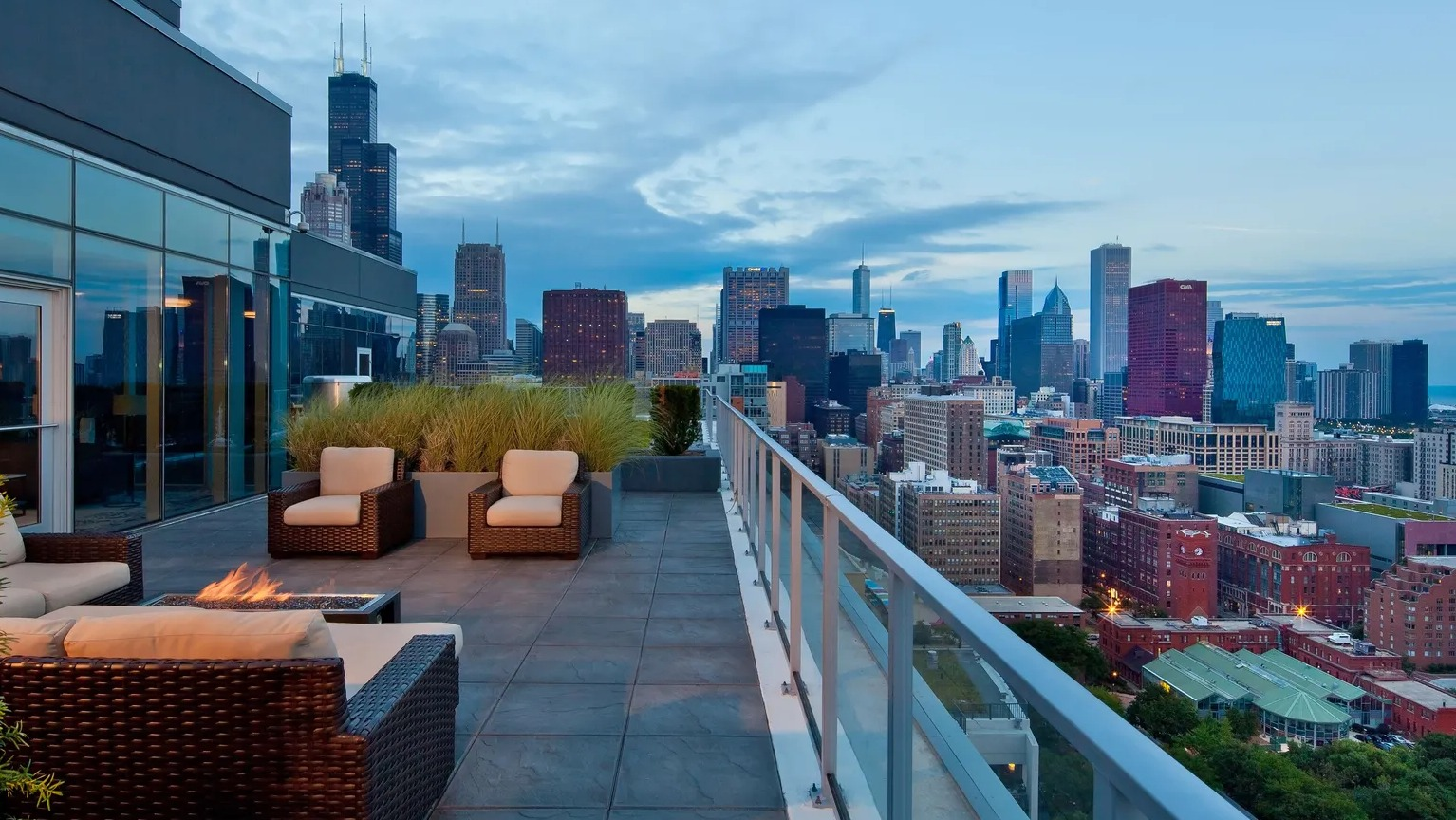 Rooftop terrace with lounge seating, fire pit, and panoramic views of the Chicago skyline at 1000 South Clark apartments