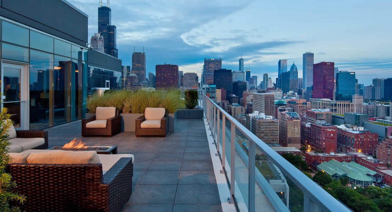 Rooftop terrace with lounge seating, fire pit, and panoramic views of the Chicago skyline at 1000 South Clark apartments
