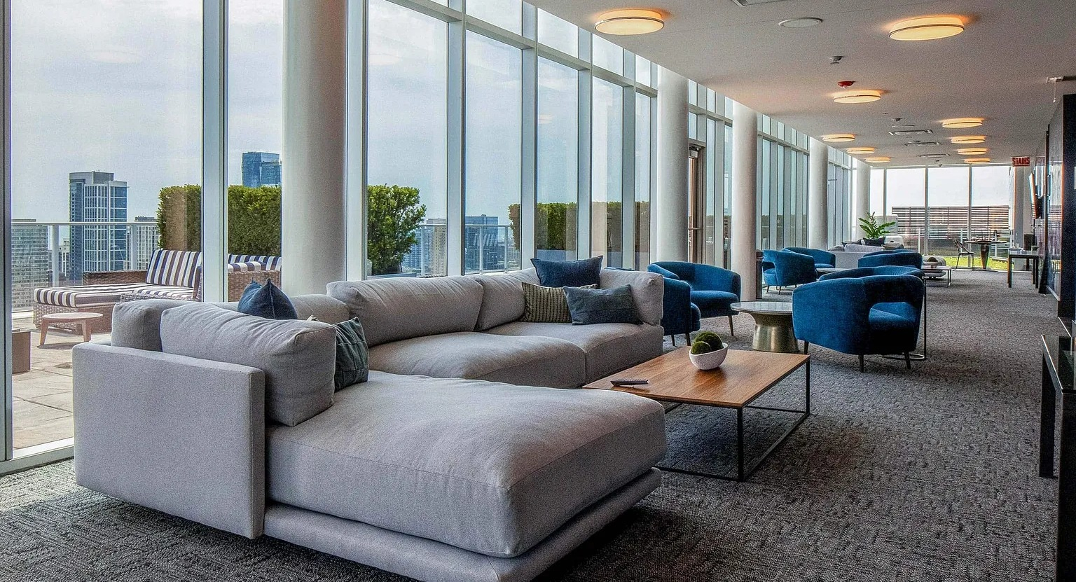 Stylish sky lounge with plush seating, floor-to-ceiling windows, and access to outdoor terrace overlooking the Chicago skyline at 1000 South Clark