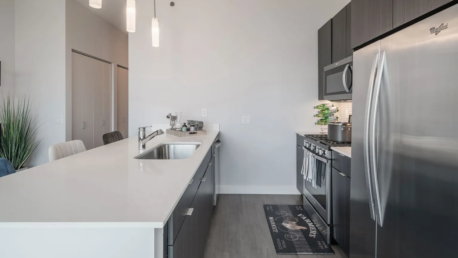 Stylish kitchen with large island, pendant lighting, stainless appliances, and modern cabinetry at 1000 South Clark apartments in Chicago