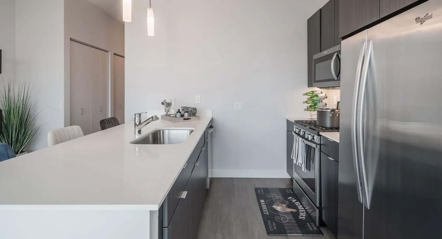 Stylish kitchen with large island, pendant lighting, stainless appliances, and modern cabinetry at 1000 South Clark apartments in Chicago