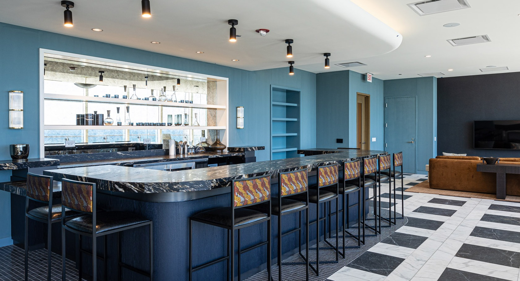Stylish Harbor Bar featuring a sleek marble counter, barstool seating, and modern finishes at 1000M Apartments in Chicago