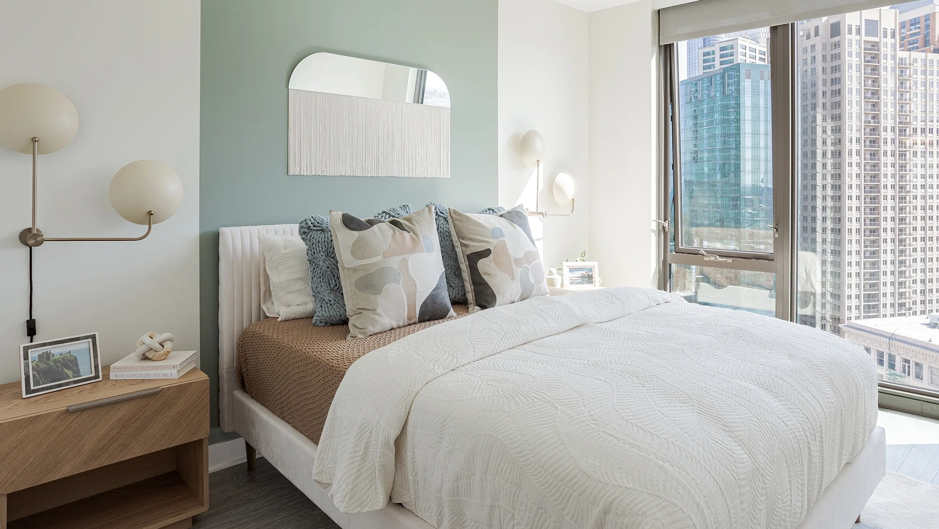 Bright modern bedroom with floor-to-ceiling windows, city views, and stylish décor at 1001 South State apartments in Chicago