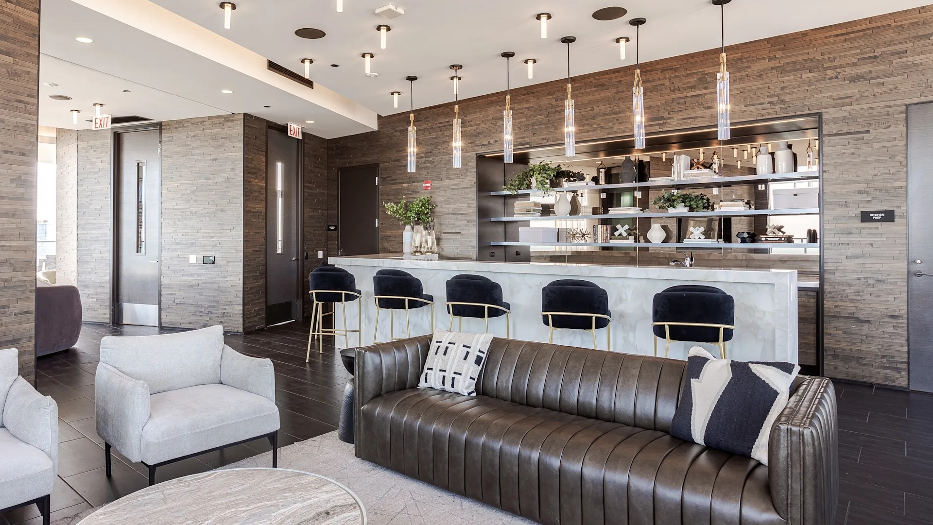 Clubroom at 1001 South State with modern leather and fabric seating, pendant lights, and a sleek bar setup for socializing in Chicago