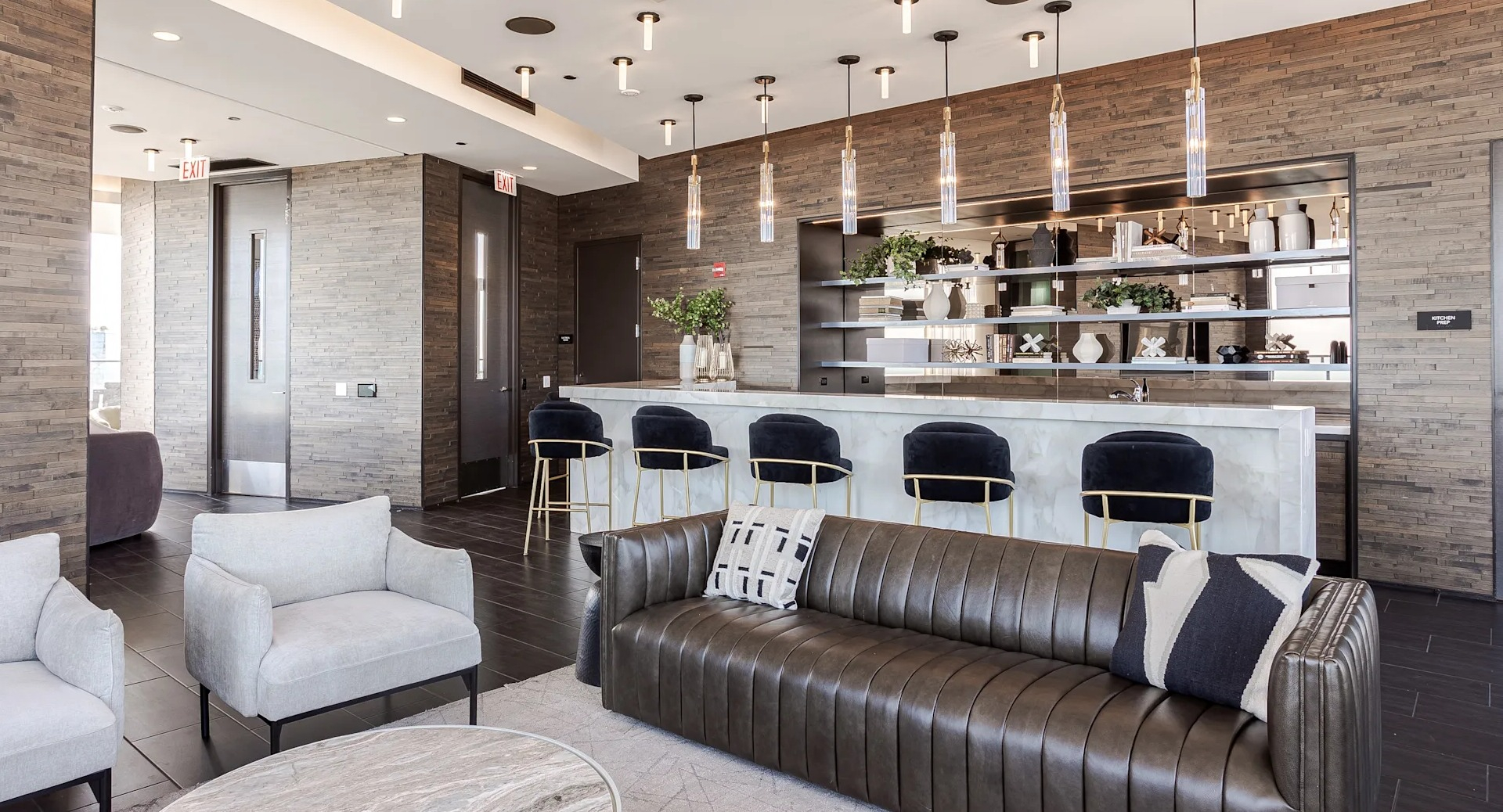 Clubroom at 1001 South State with modern leather and fabric seating, pendant lights, and a sleek bar setup for socializing in Chicago