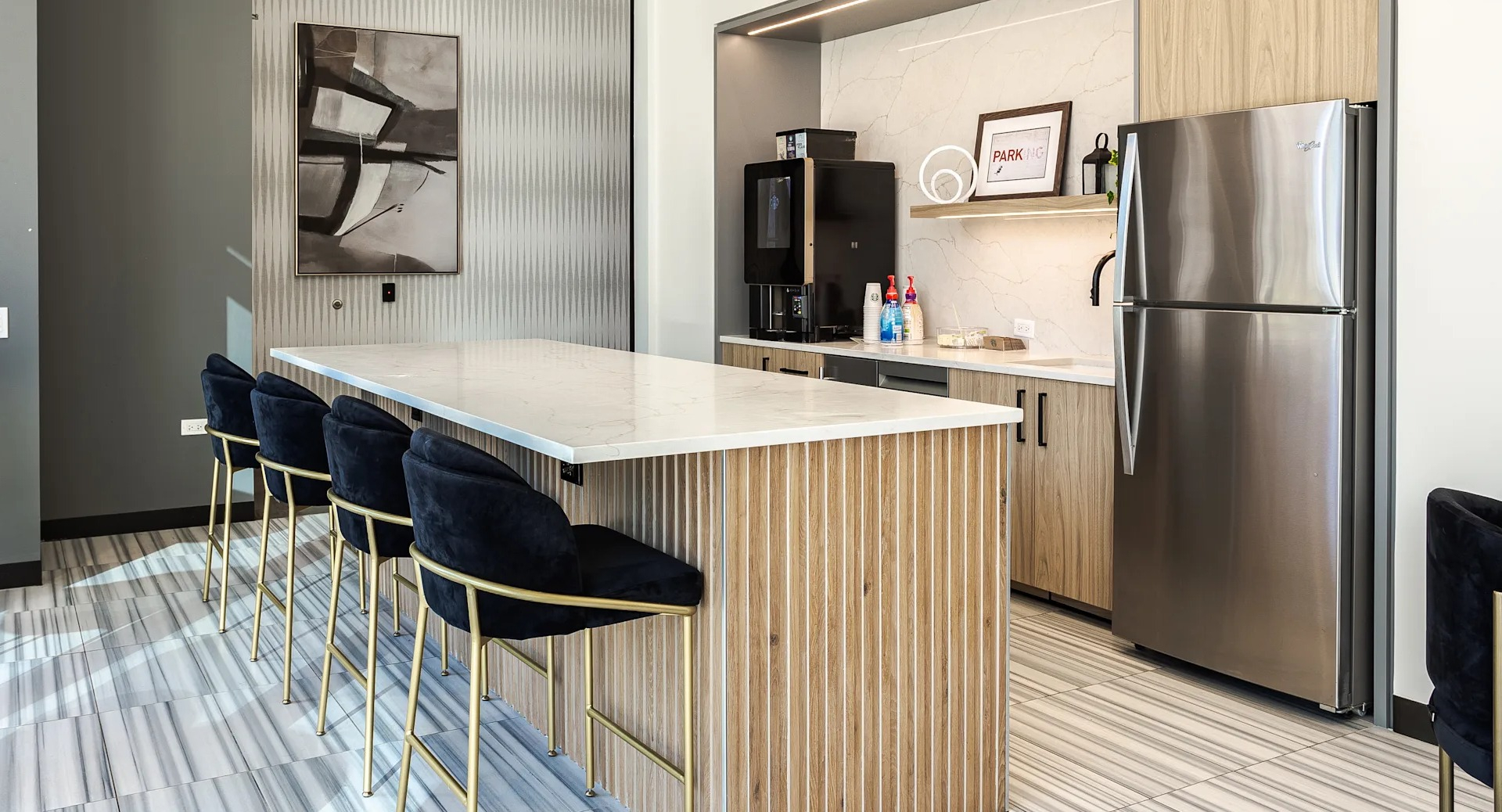 Contemporary kitchen and bar lounge with sleek countertops, stainless steel appliances, and seating at 1001 South State apartments