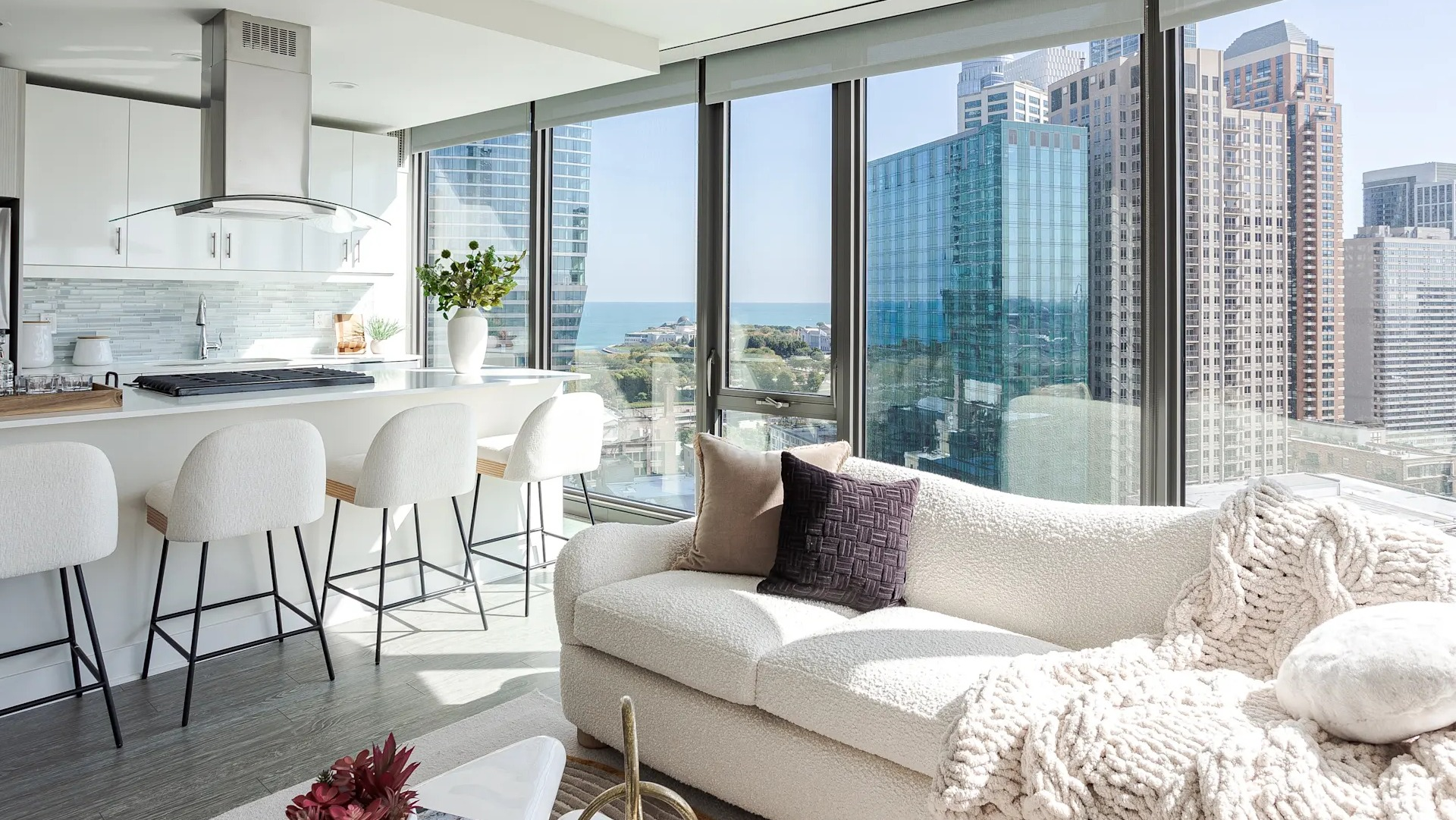 Contemporary living room with large windows, natural light, and city skyline views at 1001 South State apartments in Chicago