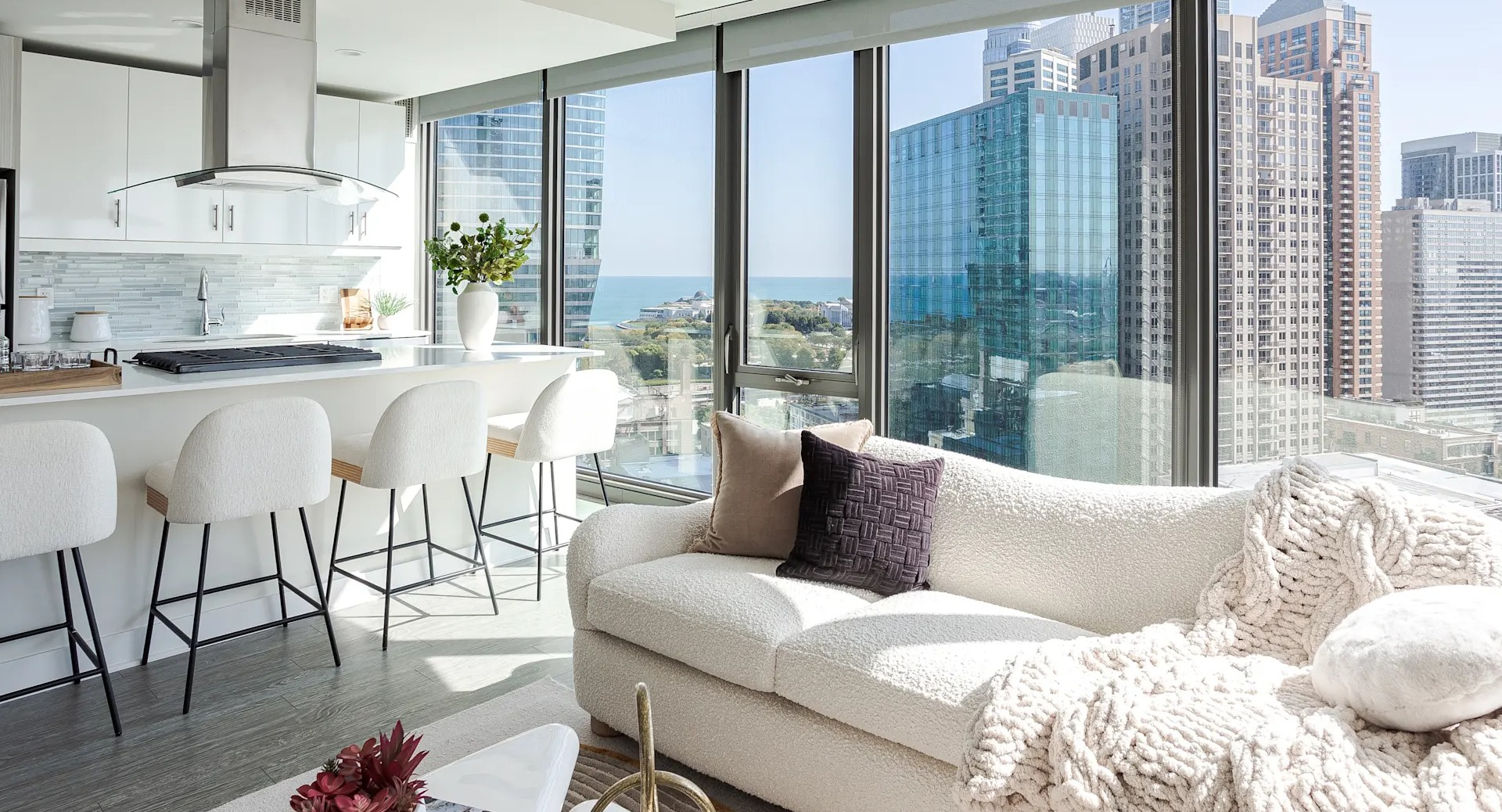 Contemporary living room with large windows, natural light, and city skyline views at 1001 South State apartments in Chicago