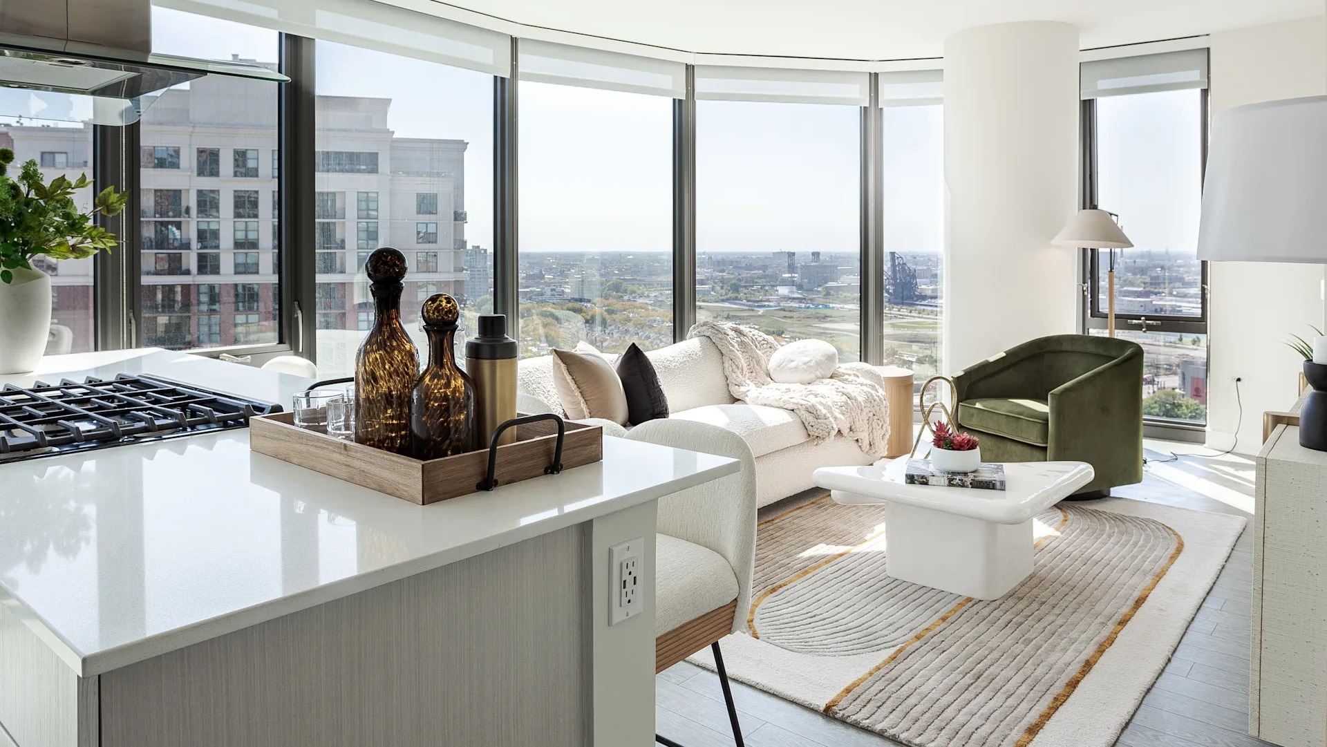 Spacious open-concept living area with floor-to-ceiling windows and kitchen island at 1001 South State apartments in Chicago