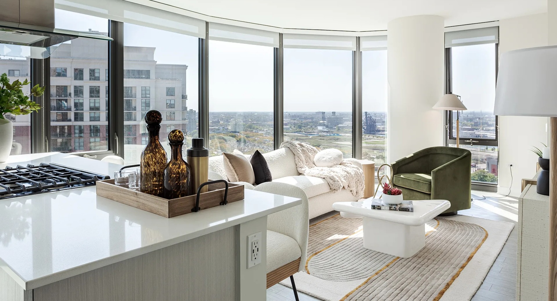 Spacious open-concept living area with floor-to-ceiling windows and kitchen island at 1001 South State apartments in Chicago