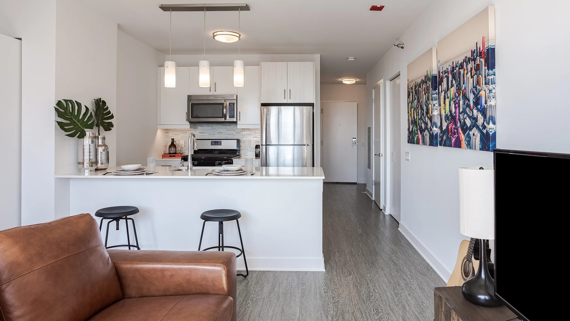 Open-layout studio at 1001 South State with a breakfast bar, pendant lights, stainless steel appliances, and bright modern design in Chicago