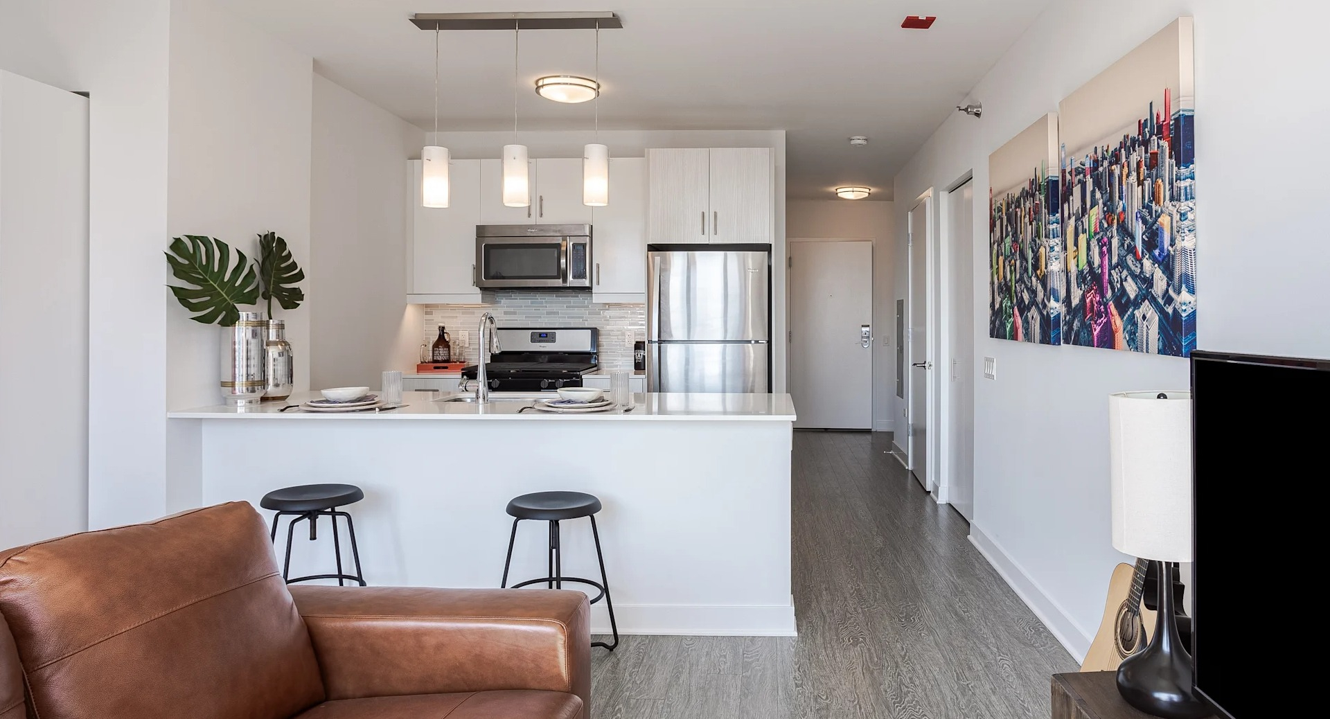 Open-layout studio at 1001 South State with a breakfast bar, pendant lights, stainless steel appliances, and bright modern design in Chicago