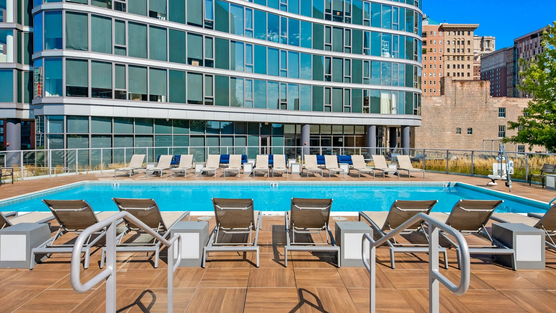 Resort-style pool deck with loungers and modern design overlooking city buildings at 1001 South State apartments in Chicago