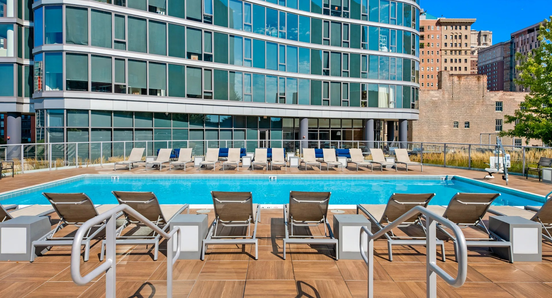 Resort-style pool deck with loungers and modern design overlooking city buildings at 1001 South State apartments in Chicago