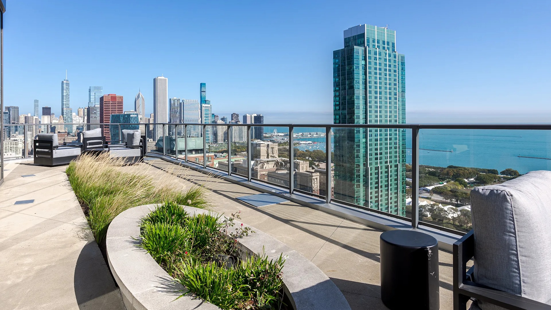 Rooftop terrace at 1001 South State featuring lounge seating, landscaped planters, and sweeping views of Chicago’s skyline and Lake Michigan