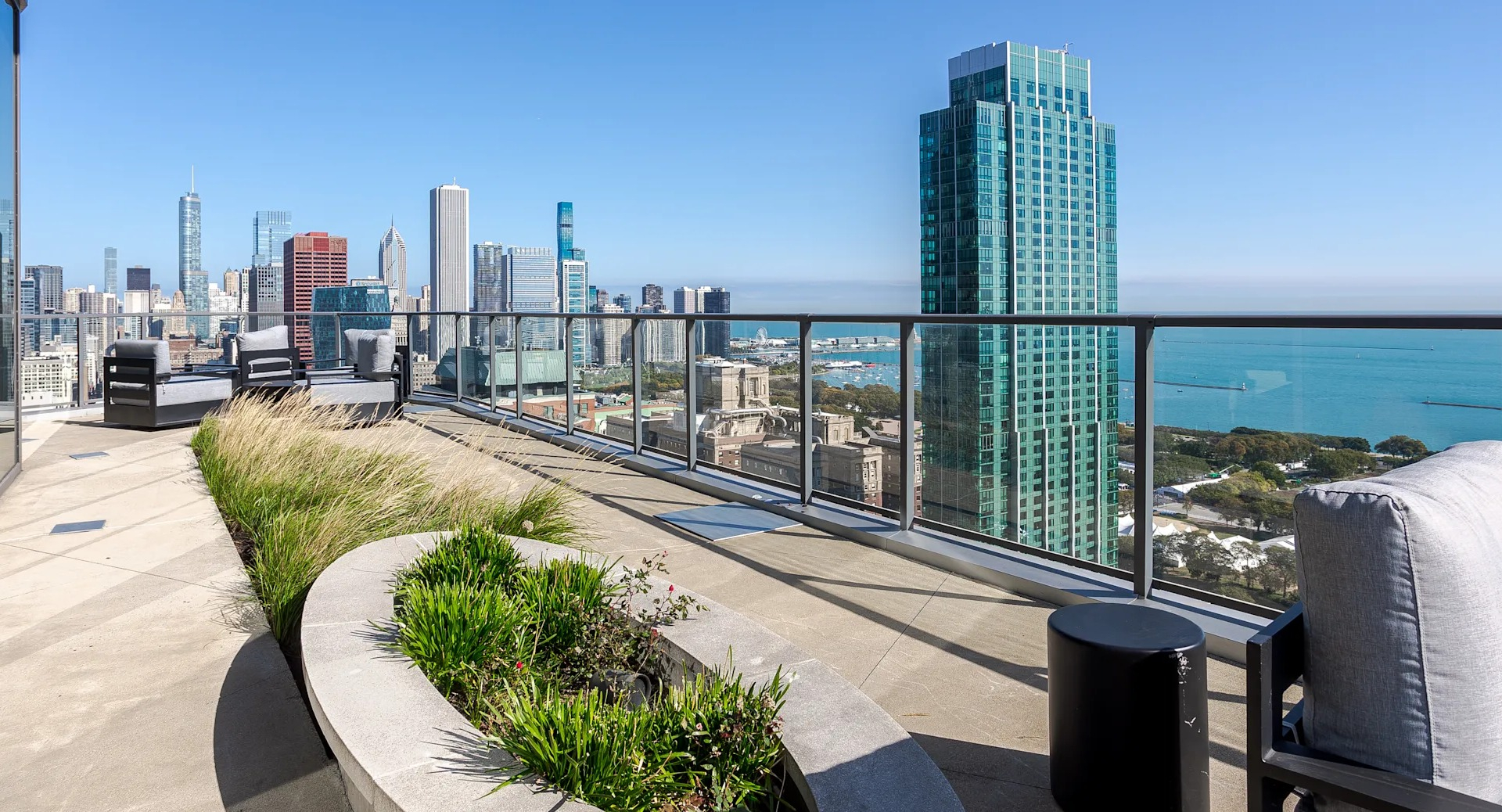 Rooftop terrace at 1001 South State featuring lounge seating, landscaped planters, and sweeping views of Chicago’s skyline and Lake Michigan
