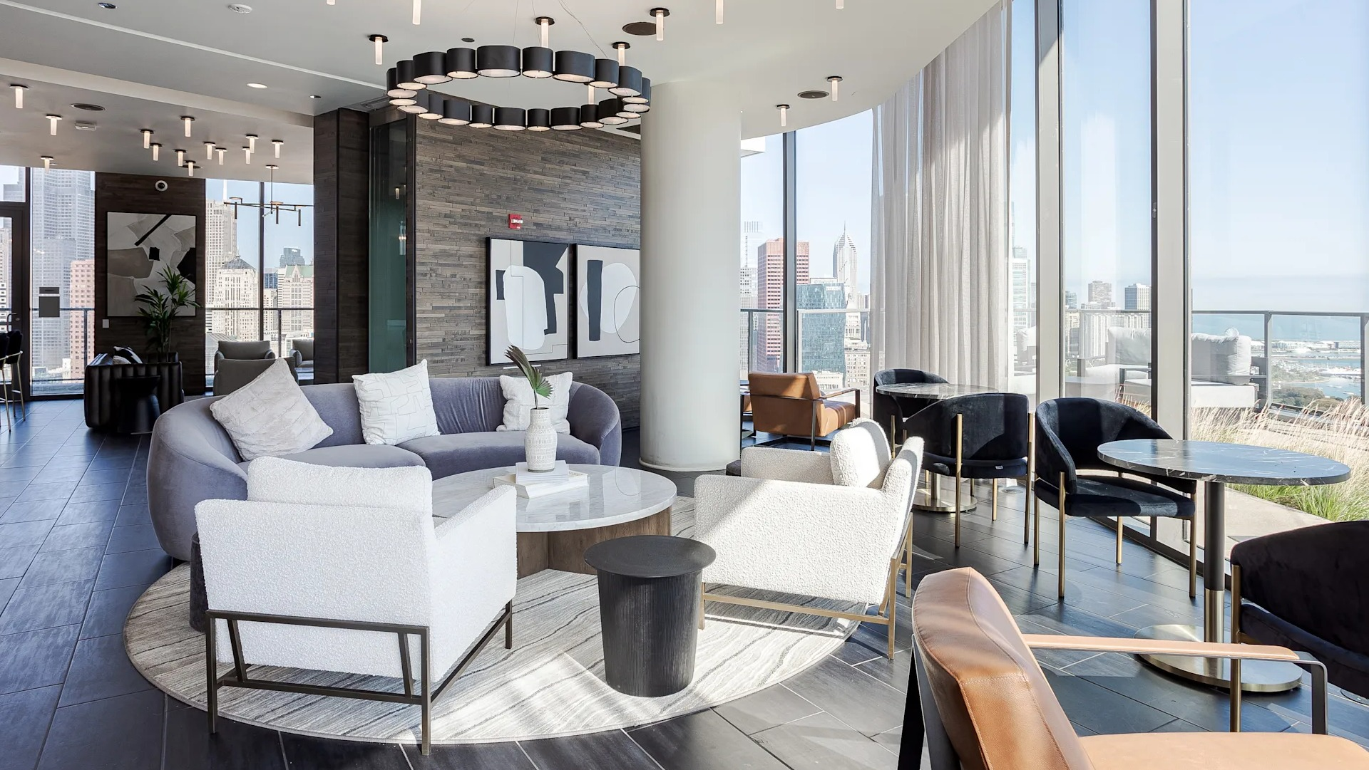 Sky lounge at 1001 South State with floor-to-ceiling windows, modern sofas, and multiple seating areas overlooking Chicago’s skyline