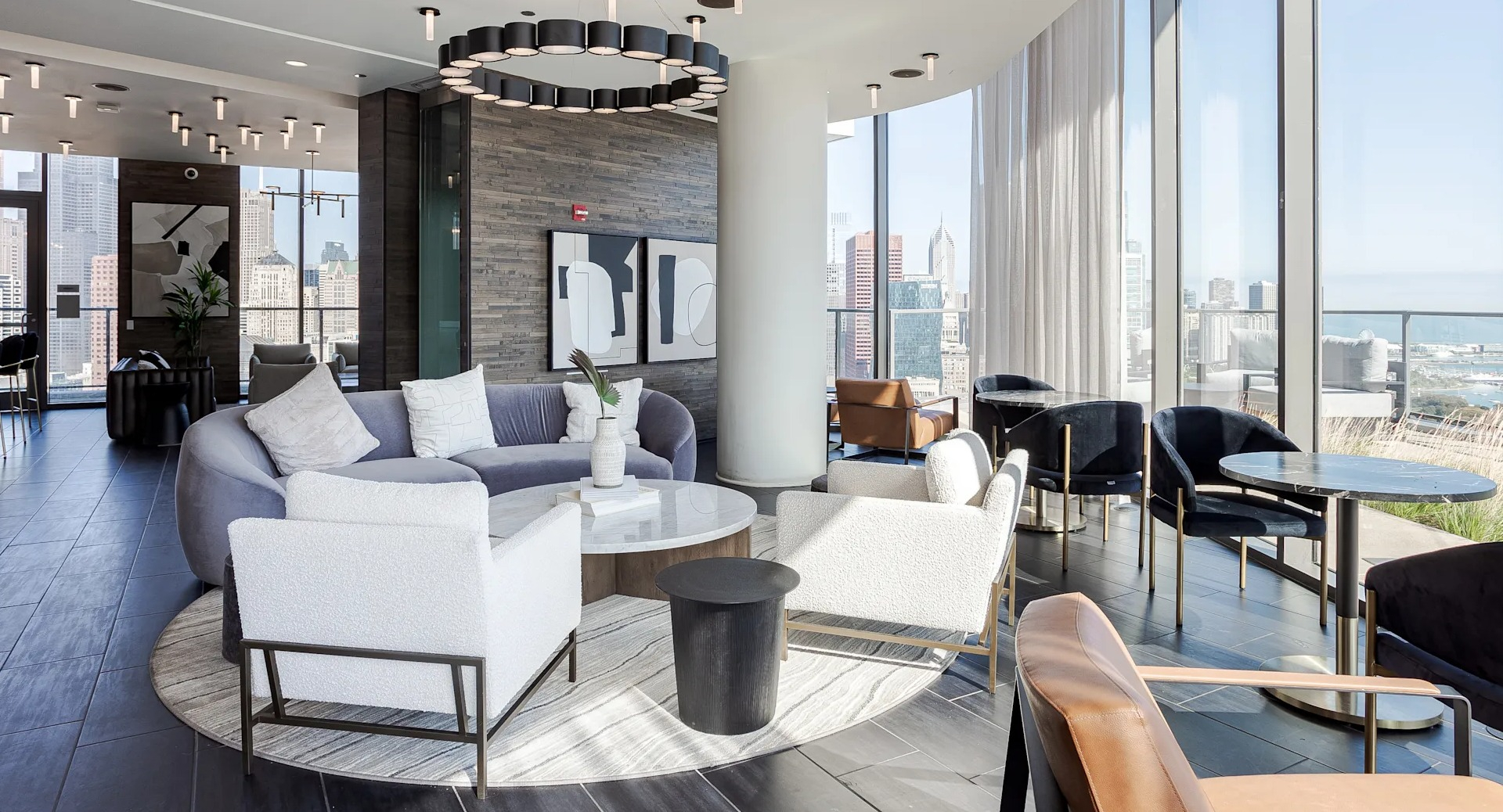 Sky lounge at 1001 South State with floor-to-ceiling windows, modern sofas, and multiple seating areas overlooking Chicago’s skyline