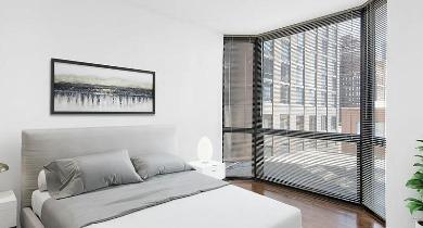 Modern bedroom with tall windows, minimalist furniture, and city views at 1100 North Dearborn apartments in Chicago