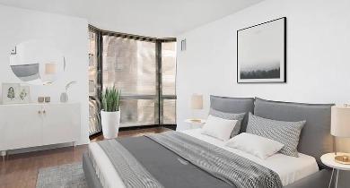 Cozy bedroom with gray bedding, stylish lighting, and bay window view at 1100 North Dearborn apartments in Chicago