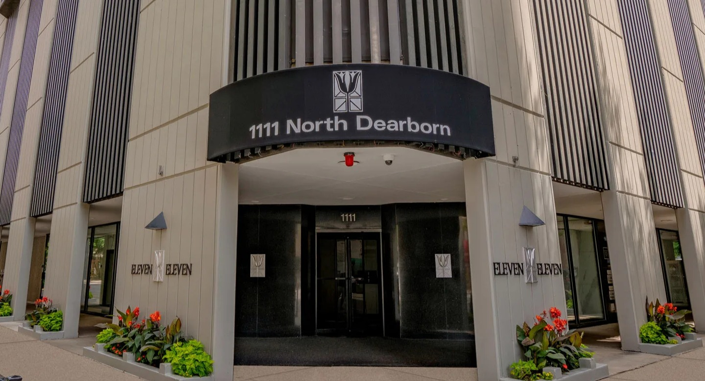 Welcoming entrance at 1111 N Dearborn in Chicago’s Gold Coast, featuring a canopy and landscaped planters—steps from neighborhood dining, shopping, and transit