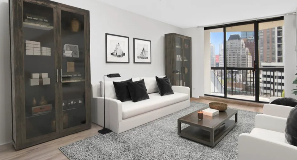 Bright living room with two sofas, glass cabinets, and a balcony with floor-to-ceiling windows at 1120 N LaSalle apartments in Chicago