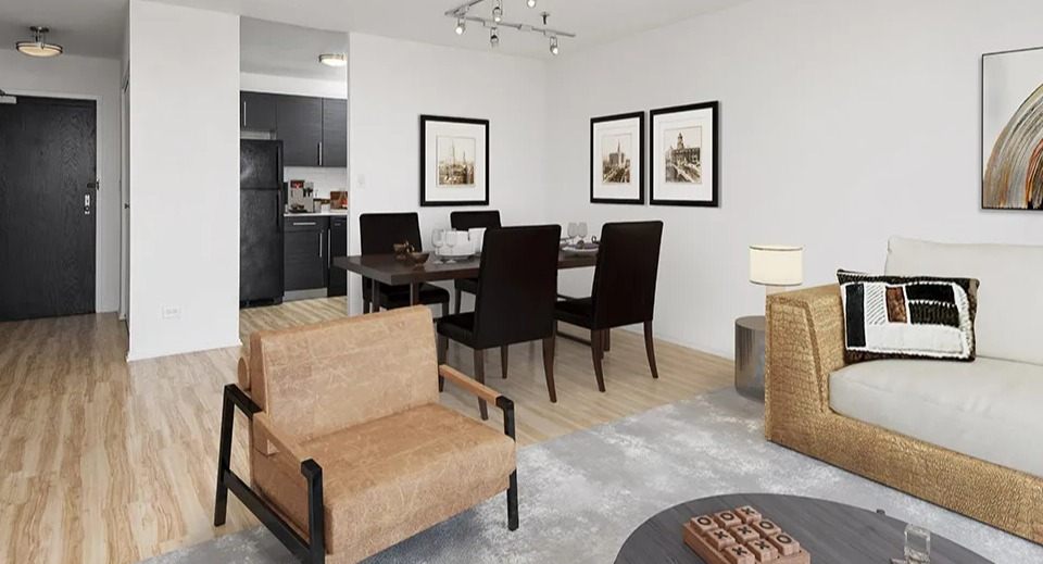 Open-concept living and dining space with modern furniture, framed art, and kitchen view at 1120 N LaSalle apartments in Chicago