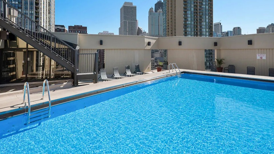 Rooftop swimming pool with lounge chairs and skyline views at 1120 N LaSalle apartments in Chicago’s Gold Coast neighborhood