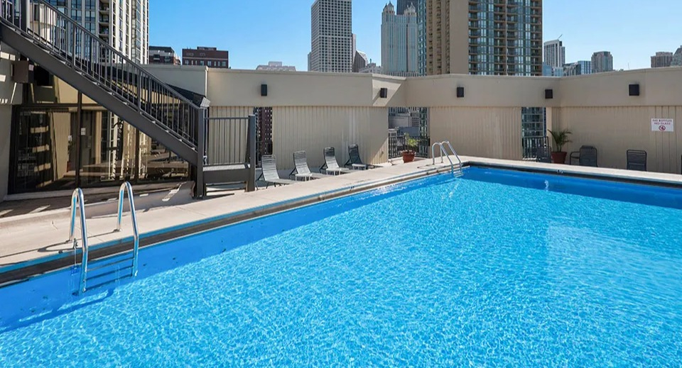 Rooftop swimming pool with lounge chairs and skyline views at 1120 N LaSalle apartments in Chicago’s Gold Coast neighborhood
