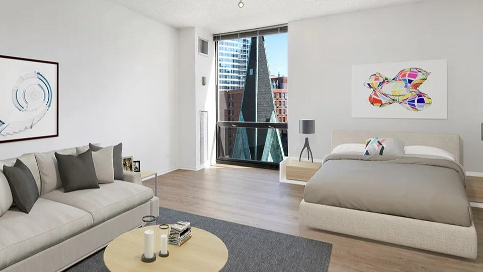 Spacious bedroom with a bed, sofa, large artwork, and floor-to-ceiling windows at 1120 N LaSalle apartments in Chicago
